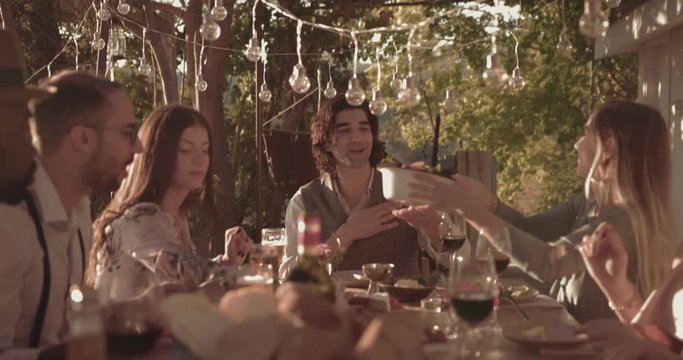 Young multi-ethnic friends having mediterranean lunch at village cottage