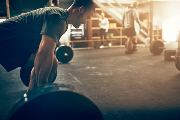 Naklejka premium Young man preparing to lift weights during an exercise class
