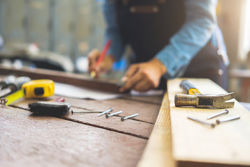 Carpenter working on woodworking machines in carpentry shop. A man works in a carpentry shop.