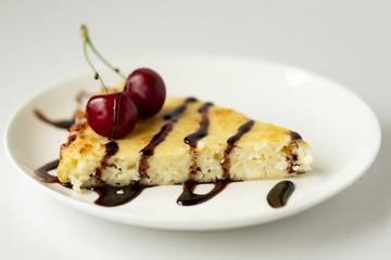 Dessert-cheesecake with cherry berries and chocolate sauce. Isolated on white