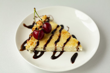 Dessert-cheesecake with cherry berries and chocolate sauce. Isolated on white