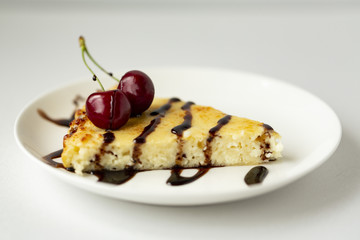 Dessert-cheesecake with cherry berries and chocolate sauce. Isolated on white