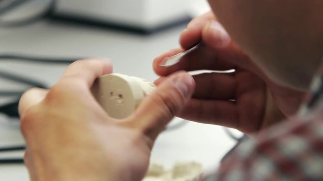 Dentist makes a dental implant prosthesis made of plaster cast. Orthopedic dentistry, prosthetics. Smile design artist working on teeth.