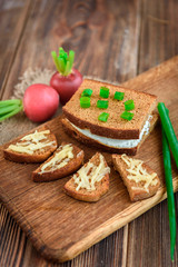 Bread with fried egg, cheese6 red radish and green onion on wooden background.