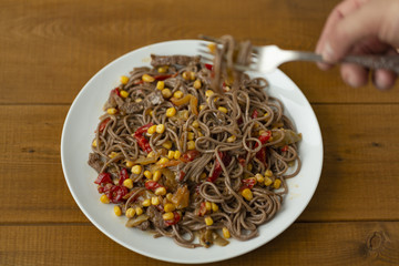 Soba noodles with beef, corn, onions and sweet peppers. Top view