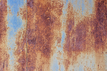 Metallic blue background  is almost entirely covered with rust,