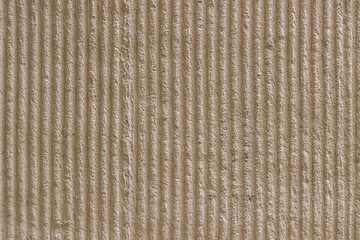 Light beige wall with decorative plaster vertical stripes.