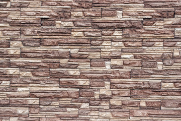 Decorative brown wall artificial torn stone background, texture.