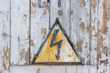 Old sign danger high voltage against background old wooden boards.