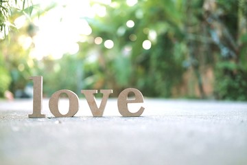 Wooden letters word "LOVE" on concrete floor.Love text in nature garden.Use for Valentine day concept background.Wooden alphabets & Words.Copy space.