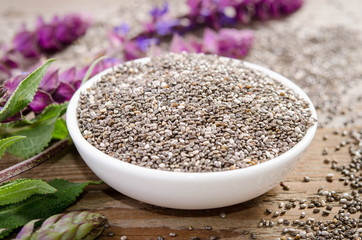 Chia seed healthy superfood with flower over wooden table