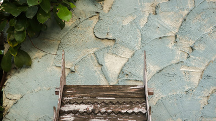 Wooden Roof Pattern with Peeling White Paint on Rough Painted Teal Wall - Green Leaves from the Garden - Miniature Wood House - Thailand