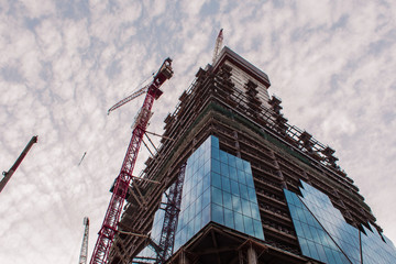Fototapeta premium Construction of high-rise building. Construction cranes and skyscraper 