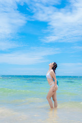 Young woman in bikini standing with  enjoying hot summer day on the beautiful beach