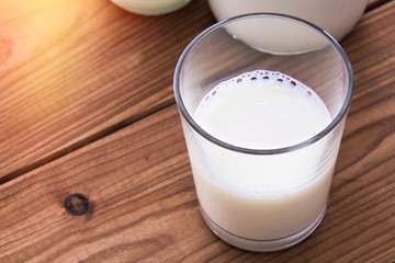 glass and bottle of milk on wooden table