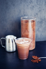 Ingredients for cocoa chocolate drink in plastic cup on the black background