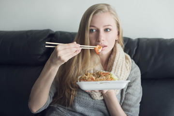 Young woman eating take away food at home