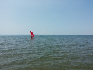 windsurfing red sail in blue sea
