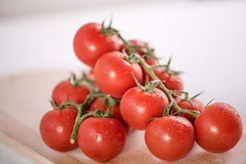 red ripe tomatoes in white bowl on white background with water drops condentation moisture 