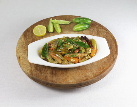 Tindora or ivy gourd curry, a healthy Indian vegetarian side dish for items like chapati and roti, in a bowl on a wooden table.