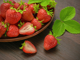 Ripe strawberries in a brown bowl on a wooden rustic table
