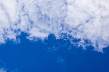 Obraz premium White clouds occupy half of the blue sky