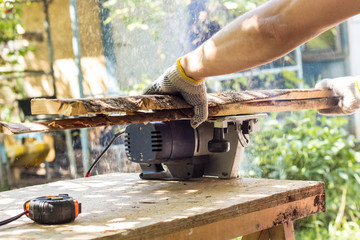 The builder cuts the board with a circular saw