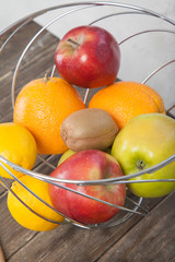 Assortment of exotic fruits close-up: kiwi, red and green apple, oranges and lemon on wooden table. Green grocery. Healthy and vegan food. Delicious fruits.