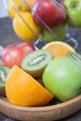 Assortment of exotic fruits close-up: kiwi, red and green apple, oranges and lemon on wooden table. Green grocery. Healthy and vegan food. Delicious fruits.