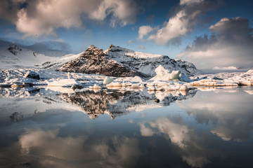 Zamarznięte jezioro Fjallsárlón z pływackimi górami lodowa, zimowy krajobraz, Islandia