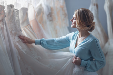 Attractive bride choosing a wedding dress