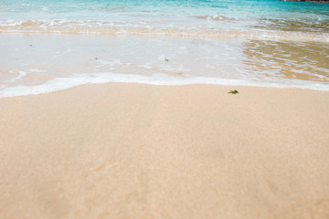 Fototapeta na wymiar Blue Water and Sea Foam on Sand