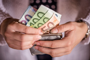 detail of girls hands holding wallet with euro currency