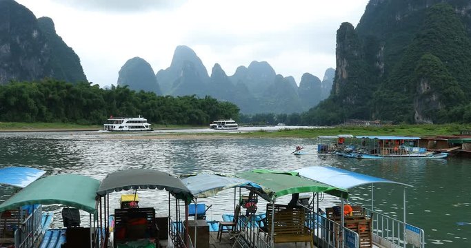 Scenic view of sailing boat along the Li River among green woods and karst mountains at Yangshuo County of Guilin, China. Yangshuo is a popular tourist destination of Asia.