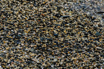 pebble beach washed by sea waves, small and various stones forming the shore