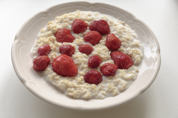Oatmeal porridge on milk with strawberries. Perfect as a healthy breakfast.