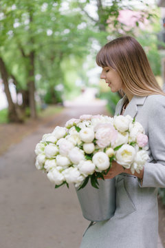 Beautiful bouquet of white peonies in woomans hands . Floral composition, daylight. Wallpaper. Vertical photo