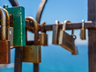 rusty padlock attached to a balustrade by the sea, a traditional way of showing love