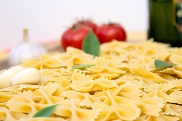 pasta Farfalle and tomatoes with herbs on an old and vintage wooden table