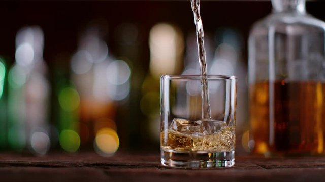 Super slow motion of pouring whiskey into glass. Filmed on cinema slow motion camera, 1000fps, ProRes 422 HQ codec.