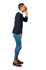 Young african american man shouting with mouth wide open and announcing something on isolated white background