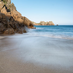 Stunning sunset landscape image of Porthcurno beach on South Cornwall coast in England