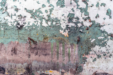An old dilapidated dirty wall with peeling paint