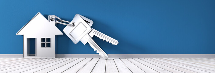 Schlüssel mit Anhänger in Hausform vor türkiser Wand