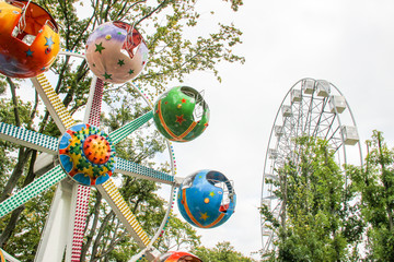 Child attraction, wheel with sphere colorful balls with stars in the park. Large ferris wheel for...