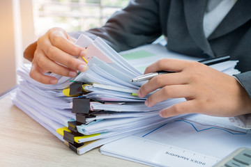 Hands young female business managers checking and arranging stack of unfinished documents reports...