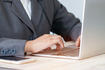 Online searching social networks by Technology Concept: Business woman using laptop computer device, hands typing text message to connect wifi for shopping online in office