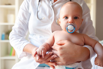Baby with pacifier in mouth at the pediatrician