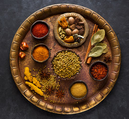 Indian spices, spicy and seasoning in bowls on a brass tray, top view