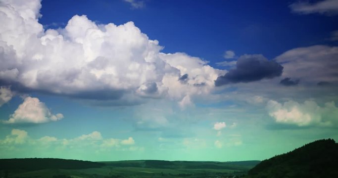 Quickly floating clouds over the field and plain at day
